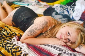 Фото тату: реалистичные розы и зеленые листья, выполненные в черно-серых тонах, покрывают плечо девушки. Детализированный рисунок татуировки выглядит очень нежно.