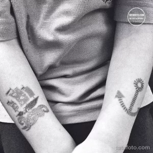 Фото парных татуировок на запястьях: якорь с солнечными лучами и летящая чайка. Выполнены в черно-белой гамме в минималистичном стиле.