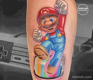 Фото яркой татуировки с изображением Марио из игры Super Mario, едущего на скейтборде, выполненной на руке с использованием ярких цветов и стилизованного фона.