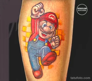 Фото яркой татуировки с изображением Марио из игры Super Mario, выполненной на руке с использованием ярких цветов и элементов фона.
