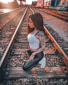 Фото тату на руке женщины с элегантным рисунком роз и теней в стиле blackwork. Детализированный рисунок татуировки выполнен в черно-белых тонах.
