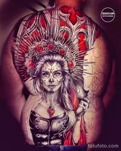 Фото тату в стиле Sugar Skull (сахарный череп) с ярким макияжем и цветами на спине девушки. Красочный рисунок татуировки.