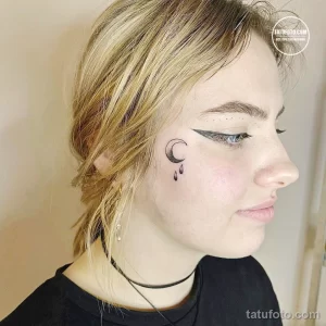 Фото минималистичной татуировки на шее с изображением полумесяца и трех капель. Тонкие линии и лаконичный дизайн.