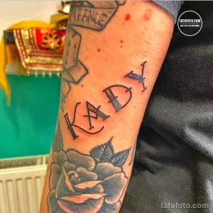 Фото тату: на руке изображена надпись "KADY" и красная роза, рядом - татуировка в виде игральной карты.