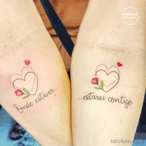 Фото парных тату: сердца с розовыми бутонами и надписью 'Onde estiver...estarei contigo' на предплечьях двух людей.