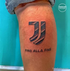 Фото тату на руке с изображением логотипа футбольного клуба Juventus и надписью 'FINO ALLA FINE'. Черно-белый рисунок.