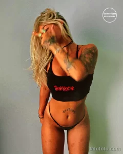 Фото тату на теле с надписями 'dangerous' и 'heaven'. Черно-белый рисунок в каллиграфическом стиле.