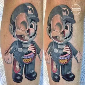 Фото тату с изображением зомби Марио из игры Super Mario Bros. с видимыми анатомическими деталями. Рисунок выполнен в ярком и детализированном стиле.