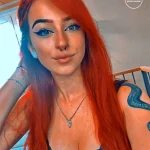 Фотография молодой девушки с множеством татуировок на теле, демонстрирующая современный стиль и индивидуальность. Татуировки выполнены в различных техниках.