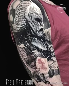 Фото тату на плече: изображение самурая в доспехах с катаной, выполненное в реалистичной черно-серой гамме.