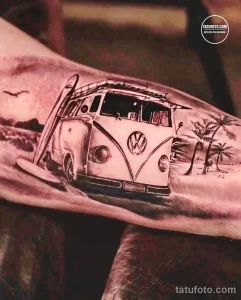 Фото татуировки с изображением старинного микроавтобуса Volkswagen, выполненной в реалистичном стиле. Тату выполнено в черно-серых тонах с высокой детализацией.
