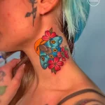 Фото тату бабочки с яркими цветами на шее. Необычный и привлекательный рисунок в стиле олдскул. Идеально подходит для девушек.