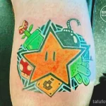 Фото тату на руке: яркая татуировка в стиле игры Super Mario с изображением звезды, грибов, труб и других элементов. Мультяшный стиль.