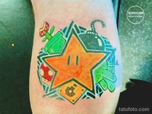 Фото тату на руке: яркая татуировка в стиле игры Super Mario с изображением звезды, грибов, труб и других элементов. Мультяшный стиль.