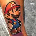 Фото тату: милая татуировка на ноге с изображением Марио из игры Nintendo. Рисунок татуировки выполнен в ярких цветах с использованием детализированной прорисовки.