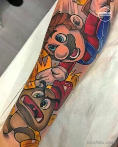 Фото тату: красочная татуировка на предплечье с изображением Марио из игры Nintendo. Рисунок татуировки выполнен в мультяшном стиле с использованием ярких цветов.