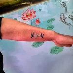Фото тату: акварельная татуировка на руке с изображением красных цветов, летящей птицы и надписи "Life".