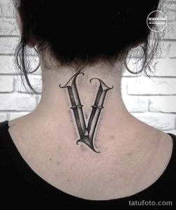 Фото тату, изображающее римскую цифру V на затылке. Простой и лаконичный рисунок татуировки выполнен черными линиями.