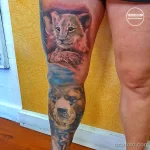 Фото реалистичной татуировки на ноге с изображением львенка, медвежонка и взрослого медведя. Яркие цвета и детализированная проработка шерсти.