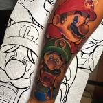 Фото тату на руке: красочное изображение Марио и Луиджи из игры Super Mario Bros, выполненное в стиле мультфильма.