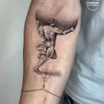 Фото тату в стиле blackwork с изображением античного героя, несущего на плечах глобус, выполненного на руке в черно-белой гамме.