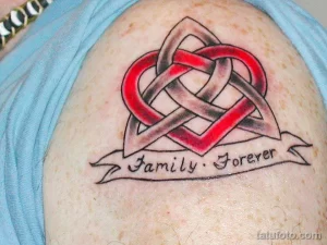Фото тату: красное сердце в кельтском стиле с надписью 'Family Forever' на плече. Эскиз татуировки, символизирующий любовь и преданность семье.
