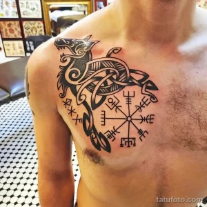 Фото тату: кельтский компас (Vegvísir) с изображением головы волка, выполненный в черно-белой гамме на груди. Мощный и символичный рисунок татуировки.