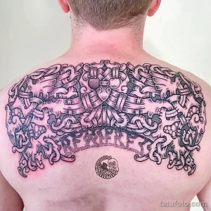 Фото тату на спине в стиле Viking с изображением сцены из скандинавской мифологии. Детализированный рисунок с использованием черного цвета и точечной техники.