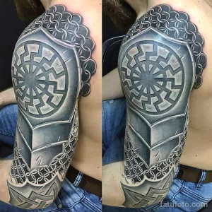 Фото тату на плече в стиле Blackwork с изображением геометрического узора и черного круга в центре. Детализированный рисунок с использованием теней.