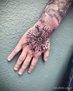 Фото татуировки кельтского компаса (Vegvísir) на руке. Черный рисунок с четкими линиями и геометрическим узором.