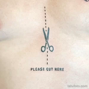 Фото тату на груди с изображением ножниц и надписью 'Please cut here'. Минималистичный и провокационный дизайн.