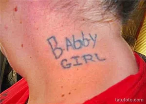 Фото тату на шее с надписью 'Baby Girl', выполненной простым шрифтом, с неровными краями.