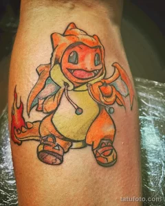 Фото татуировки Charizard из Покемона. Красочный и детализированный рисунок с изображением огненного покемона в динамичной позе.