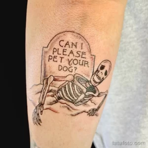 Фото тату на руке: скелет собаки с надписью 'Can I please pet your dog?'. Минималистичный стиль, черные линии.