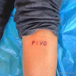 Фото тату с надписью 'PIVO' черным цветом, выполненной простым шрифтом на внутренней стороне голени. Минималистичный рисунок татуировки.