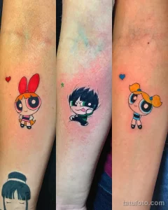 Фотография трех предплечий с татуировками персонажей мультсериала Powerpuff Girls: Blossom, Bubbles и Buttercup. Яркие цвета и четкие контуры.