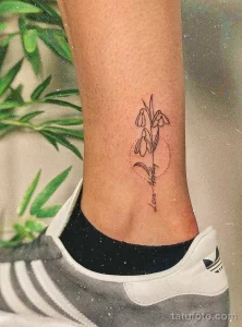 Фото тату на лодыжке с изображением двух подснежников и надписи "Love Always". Рисунок выполнен в черно-белом цвете тонкими линиями.