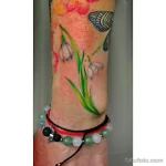 Фото тату подснежников в акварельной технике на руке. Нежные переходы цветов, создающие эффект размытости и легкости. Яркий и красочный дизайн.