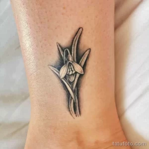 Татуировка подснежника, выполненная в технике blackwork. Контрастные тени и плотное заполнение создают эффектный и стильный образ.