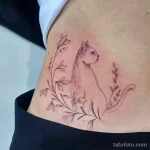 Фото тату на бедре: кошка, цветы, тонкие линии. Черно-белый рисунок татуировки в стиле графика.