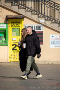 Фото уличной татуировки: мужчина с татуировками на руках и шее, идущий с девушкой.