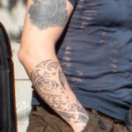 Мужчина с татуировкой трайбл узора на правой руке 2