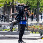Оператор иностранной телекомпании с тату рукавом на правой руке 11