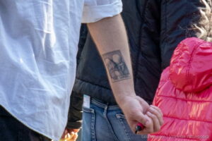 Фото татуировки на предплечье мужчины: портрет в рамке, выполненный в черно-серых тонах. Детализированный рисунок татуировки.