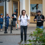 Фотография мужчины с татуировкой льва на предплечье, выполненной в реалистичном стиле. Снимок в стиле street tattoo.