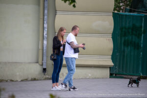 Фото мужчины, гуляющего с собакой, с видимой татуировкой на руке. Татуировка выполнена в темных тонах и имеет сложный узор.