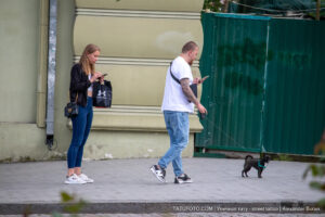 Фото мужчины, гуляющего с собакой, с видимой татуировкой на руке. Татуировка выполнена в темных тонах и имеет сложный узор.
