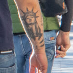 Три крепких молодых мужчины с татуировками на руках 11