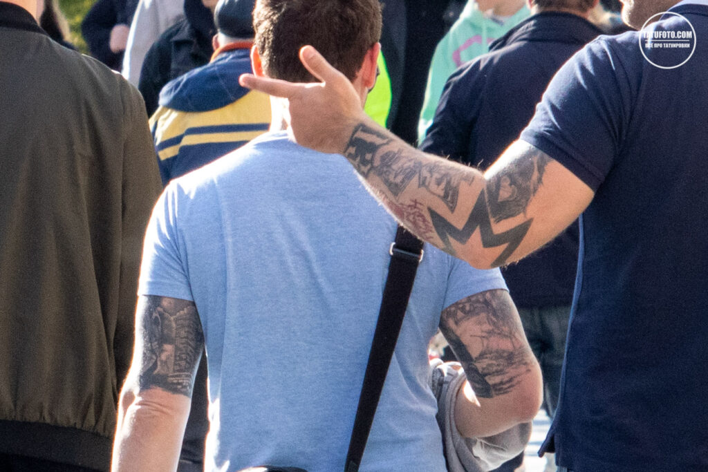 Три крепких молодых мужчины с татуировками на руках 12