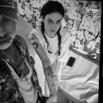 Фото татуировки на руке, изображающей абстрактные узоры и символы в черно-белом цвете. Тату выполнено в графическом стиле с использованием тонких линий.